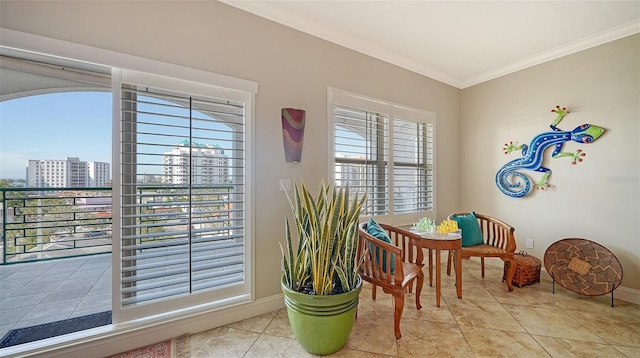 tiled dining space with ornamental molding, a wealth of natural light, a city view, and baseboards