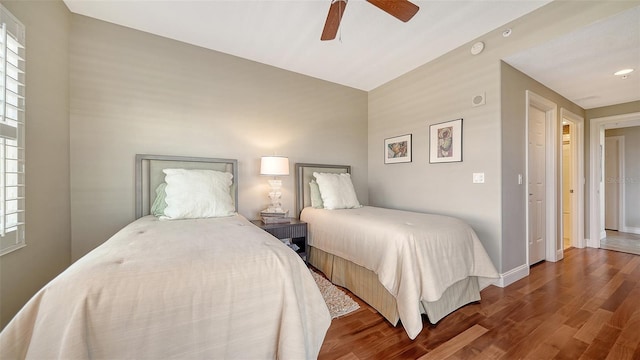 bedroom featuring ceiling fan, baseboards, and wood finished floors