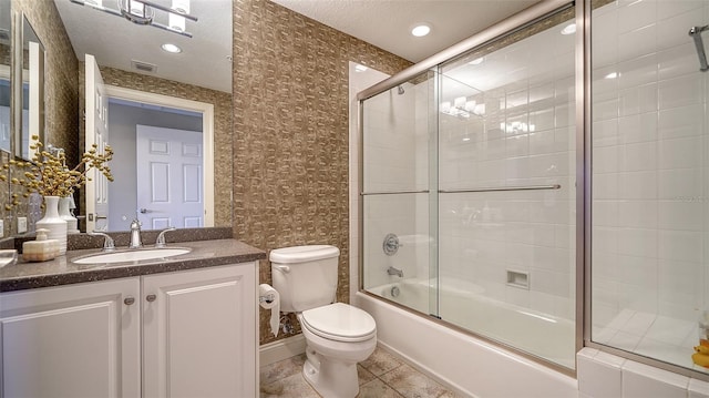 full bath featuring a textured ceiling, toilet, visible vents, combined bath / shower with glass door, and tile patterned floors