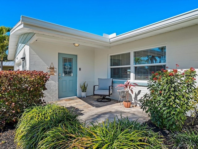 entrance to property with a patio and brick siding