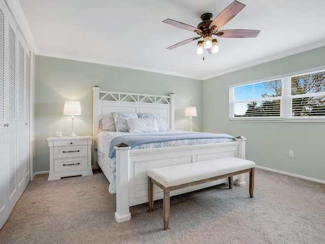 bedroom featuring crown molding, light colored carpet, ceiling fan, and a closet