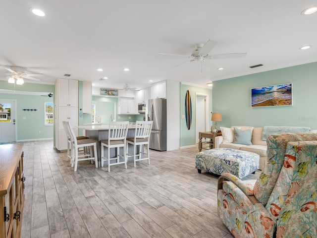5303 Coral Blvd, Bradenton, FL 34210 - living room with visible vents, light wood-type flooring, ceiling fan, and ornamental molding