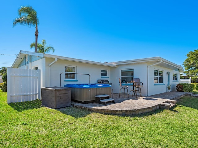 5303 Coral Blvd, Bradenton, FL 34210 - rear view of property featuring a hot tub, fence, stucco siding, a yard, and a patio