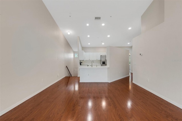 unfurnished living room featuring dark hardwood / wood-style flooring and sink