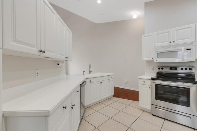 kitchen featuring sink, stainless steel appliances, white cabinets, and light tile patterned flooring