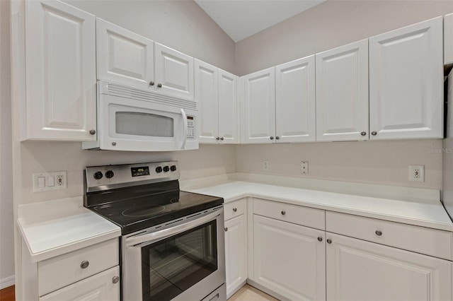 kitchen with electric stove and white cabinetry