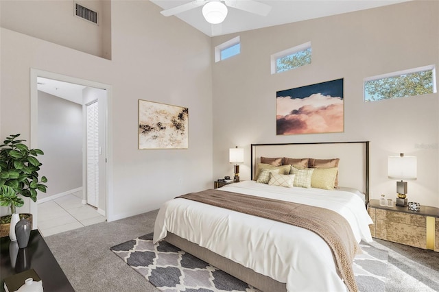 carpeted bedroom featuring ceiling fan and high vaulted ceiling