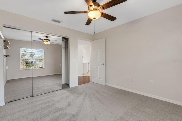 unfurnished bedroom featuring ceiling fan, a closet, and light carpet