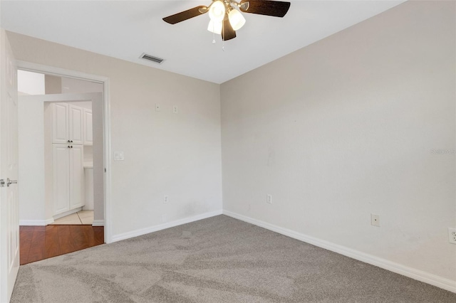 empty room with ceiling fan and light colored carpet