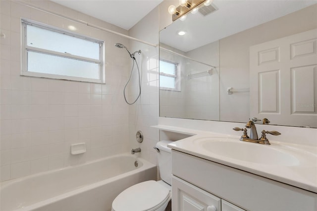 full bathroom featuring tiled shower / bath, vanity, and toilet