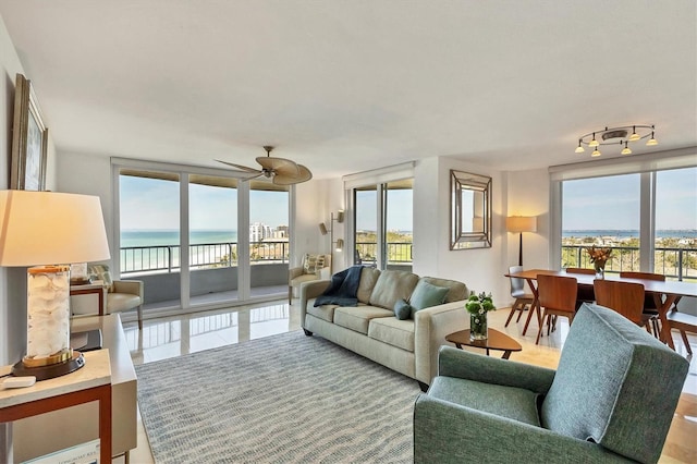 living room featuring a water view, plenty of natural light, and a wall of windows