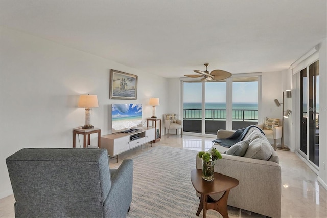 living room featuring ceiling fan and a wall of windows