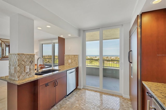 kitchen with sink, tasteful backsplash, light stone counters, kitchen peninsula, and stainless steel appliances