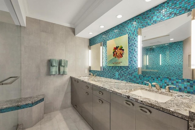 bathroom featuring a shower, tile walls, vanity, ornamental molding, and tile patterned floors