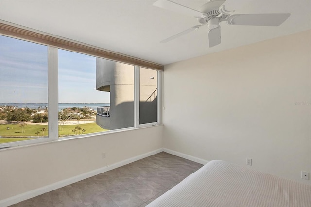 unfurnished bedroom with a water view and ceiling fan