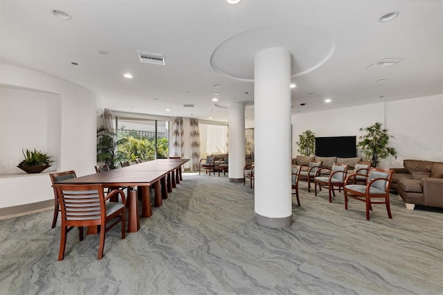 carpeted dining room with ornate columns