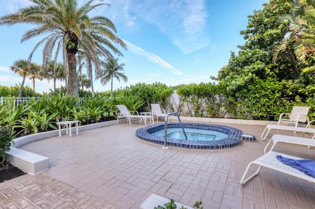 view of pool with a hot tub and a patio