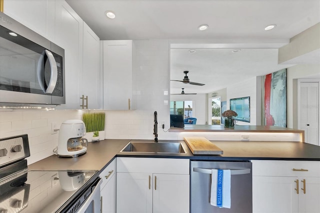 kitchen with sink, tasteful backsplash, ceiling fan, stainless steel appliances, and white cabinets