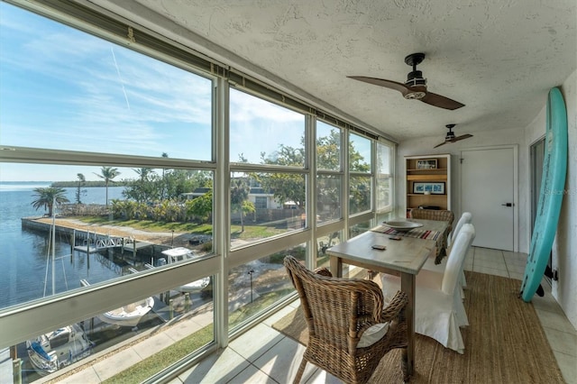 sunroom / solarium with a water view and ceiling fan