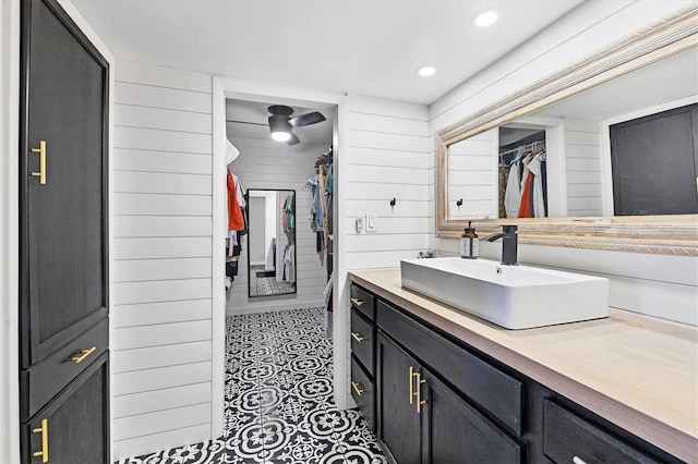 bathroom with tile patterned flooring, vanity, and wooden walls