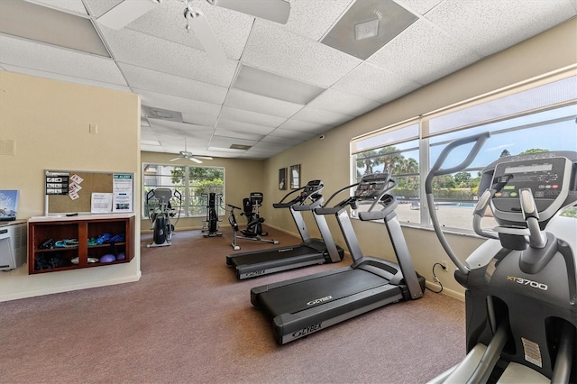 gym with a paneled ceiling and ceiling fan