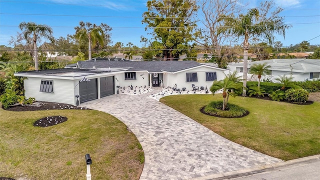 single story home featuring a garage and a front lawn