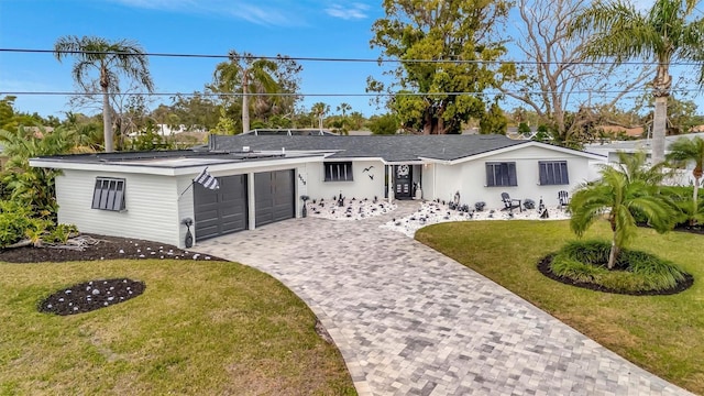 ranch-style home with a garage and a front lawn