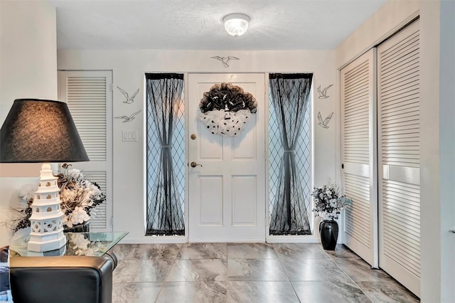 foyer entrance with a textured ceiling