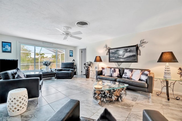 living room featuring ceiling fan and a textured ceiling