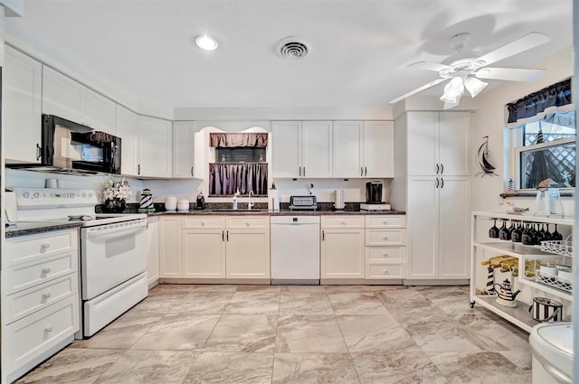 kitchen with white cabinetry, sink, dark stone countertops, ceiling fan, and white appliances