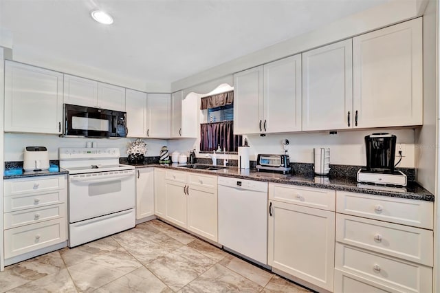 kitchen featuring white appliances, dark stone countertops, sink, and white cabinets