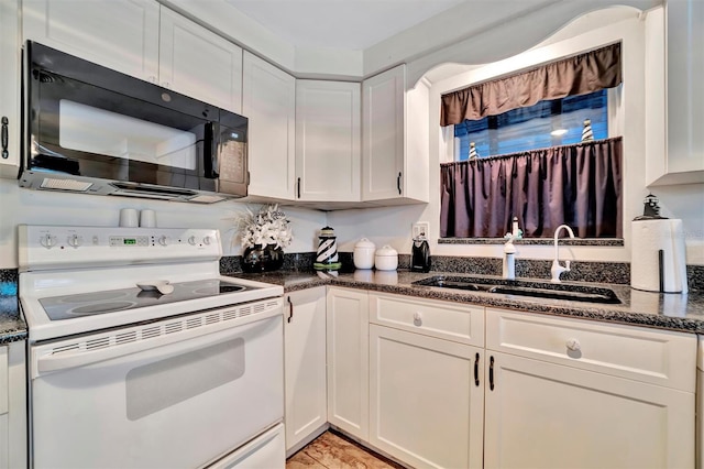 kitchen with white cabinetry, white electric range, sink, and dark stone countertops