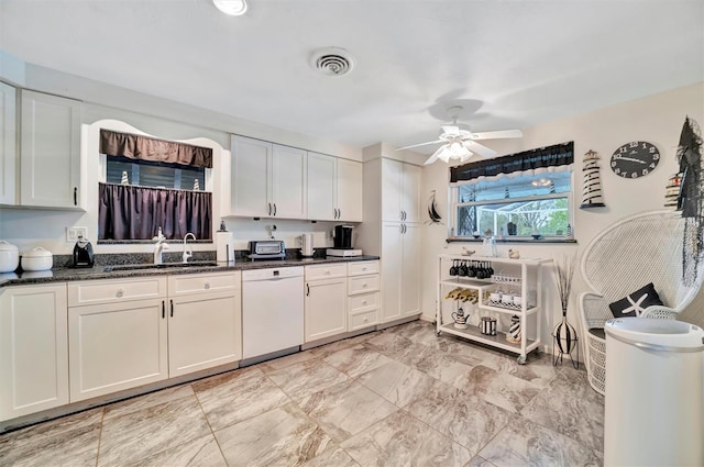 kitchen featuring white cabinetry, sink, white dishwasher, and dark stone counters