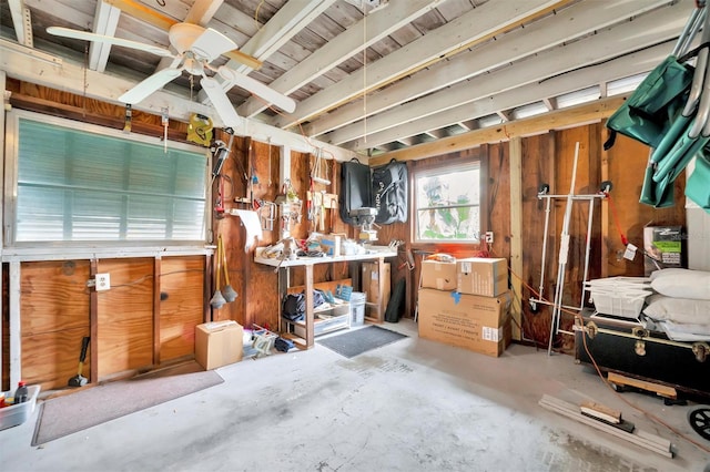 interior space featuring concrete flooring, a workshop area, and ceiling fan