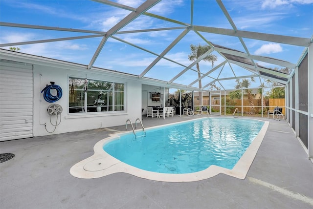 view of swimming pool with glass enclosure and a patio area