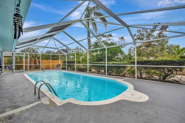 view of swimming pool featuring a patio and glass enclosure