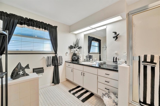 bathroom featuring tile patterned floors, vanity, and a shower with door