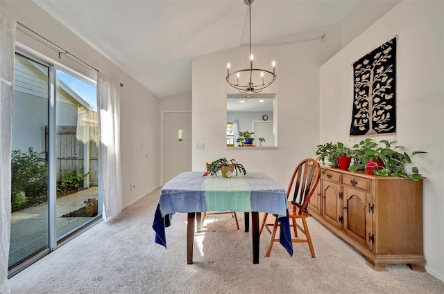 dining space featuring light colored carpet, lofted ceiling, and a notable chandelier