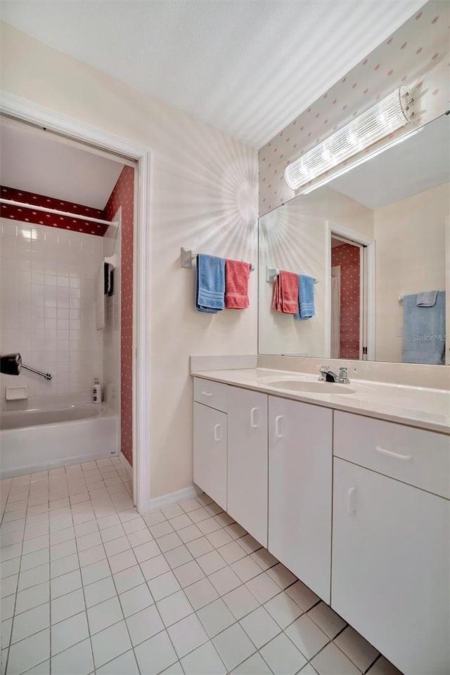 bathroom featuring tile patterned floors, vanity, and tiled shower / bath