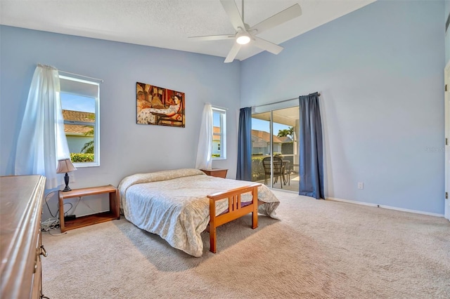 bedroom featuring access to exterior, a textured ceiling, ceiling fan, and carpet