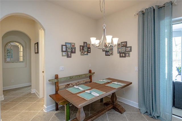 dining area with light tile patterned floors and a chandelier