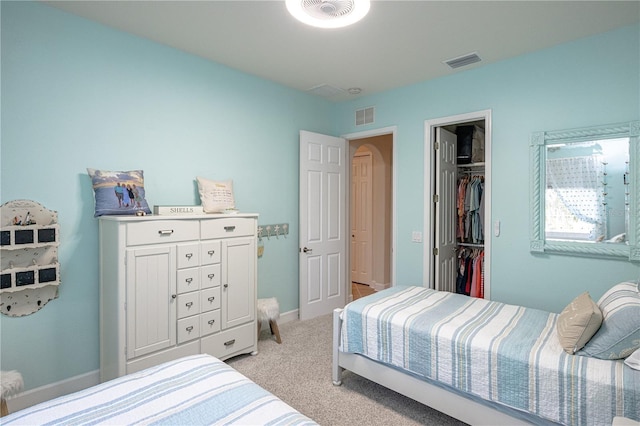 bedroom featuring a spacious closet and light carpet