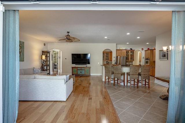 living room with ceiling fan and light hardwood / wood-style flooring