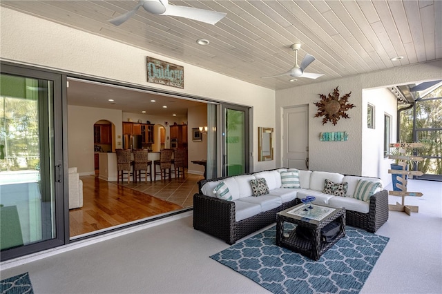 living room featuring wood ceiling and ceiling fan