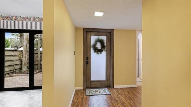 entryway with wood-type flooring and a textured ceiling