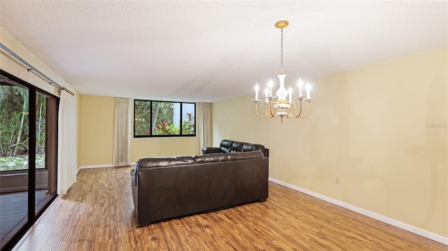 living room featuring hardwood / wood-style floors, a textured ceiling, and a chandelier