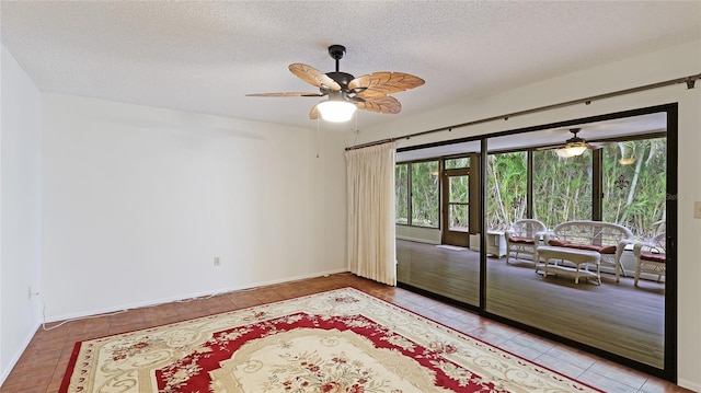 tiled spare room with ceiling fan and a textured ceiling