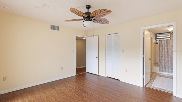 unfurnished bedroom with dark hardwood / wood-style flooring, connected bathroom, and a closet