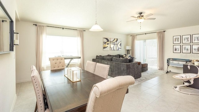 dining area with a ceiling fan and baseboards