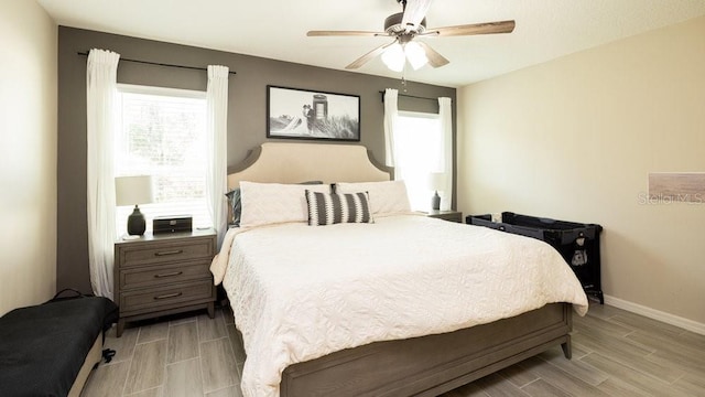 bedroom with wood finish floors, ceiling fan, and baseboards